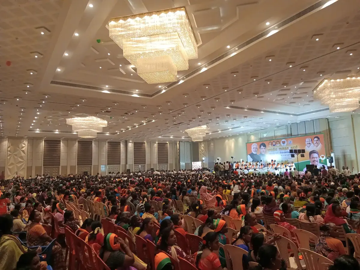 Large public gathering filling the main hall at Suganya Convention Centre, Pondicherry