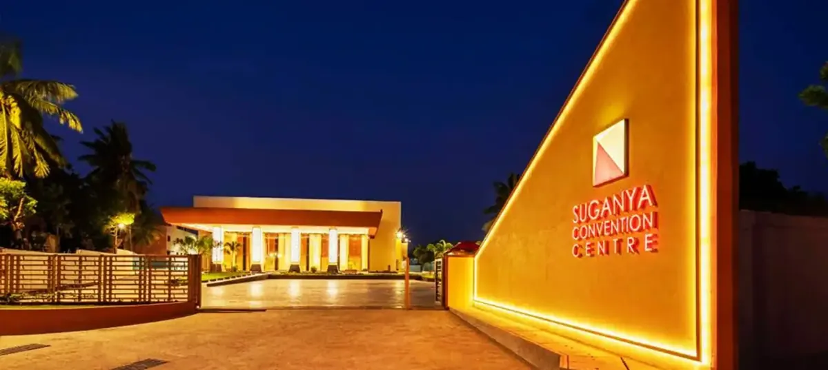 Warm layered lighting across the interior of the main hall at Suganya Convention Centre